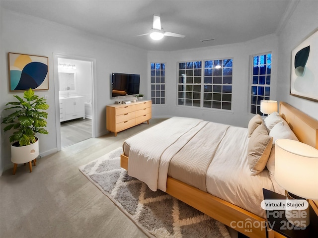 carpeted bedroom with ceiling fan and ensuite bath