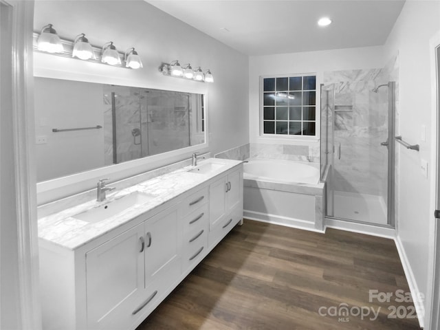 bathroom with plus walk in shower, hardwood / wood-style floors, and vanity