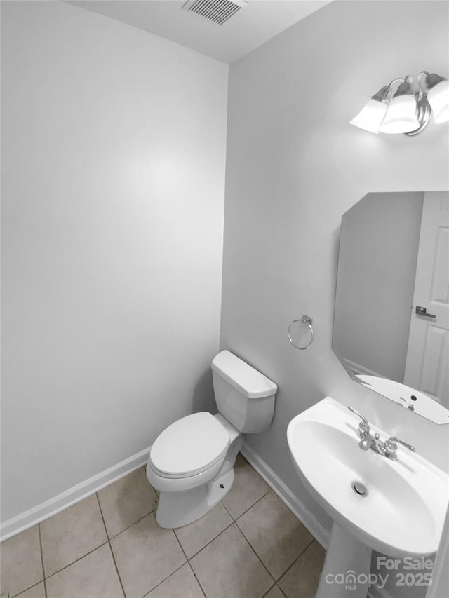 bathroom with toilet, tile patterned flooring, and sink