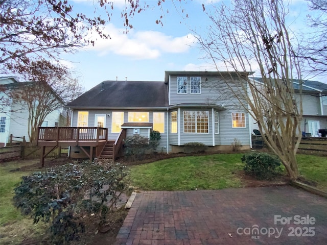 rear view of house featuring a deck and a lawn