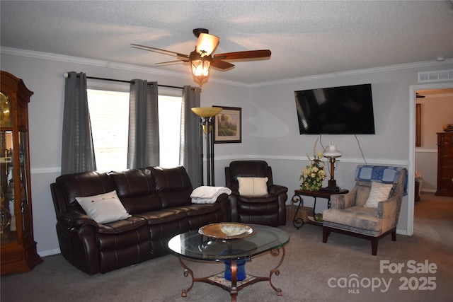 living room with ceiling fan, ornamental molding, carpet, and a textured ceiling