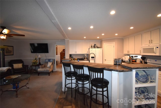 kitchen featuring white cabinetry, white appliances, ornamental molding, and a kitchen island with sink