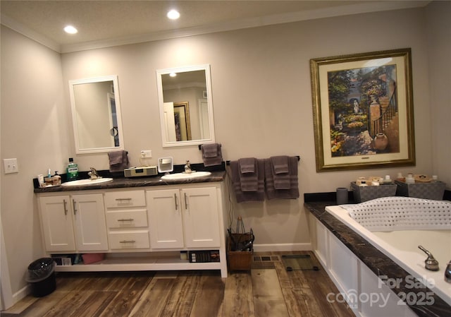 bathroom with a tub to relax in, ornamental molding, hardwood / wood-style floors, and vanity