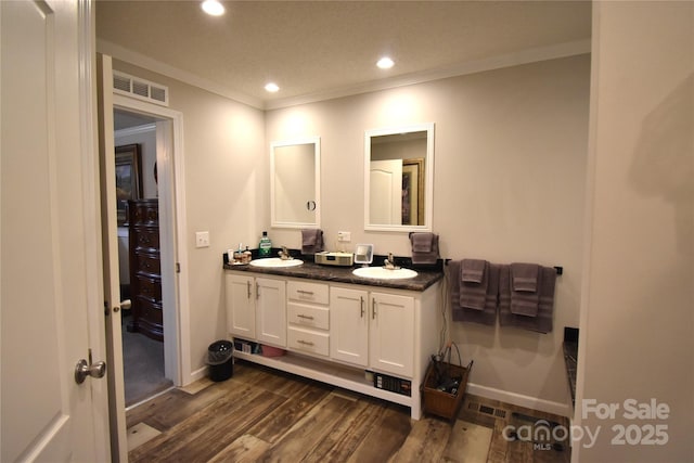 bathroom with ornamental molding, wood-type flooring, and vanity