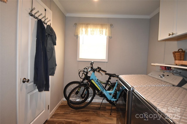 laundry room with cabinets, crown molding, dark wood-type flooring, and washing machine and dryer