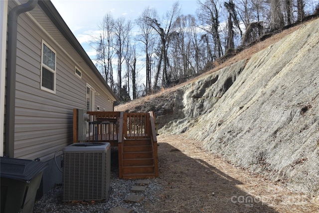 view of yard featuring cooling unit and a deck