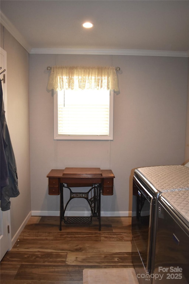 interior space featuring washing machine and dryer, baseboards, ornamental molding, and wood finished floors