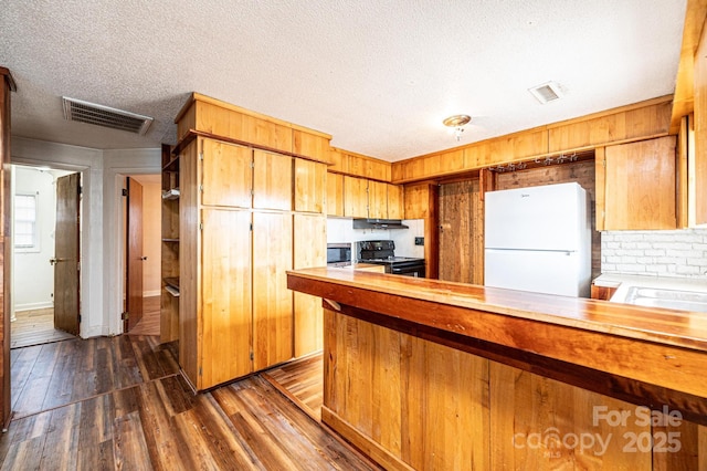 kitchen with dark wood-type flooring, sink, black electric range, a textured ceiling, and white fridge