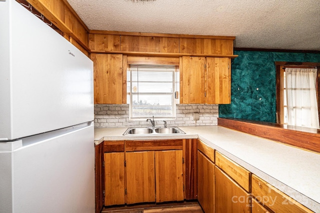 kitchen featuring sink, decorative backsplash, a textured ceiling, and white fridge