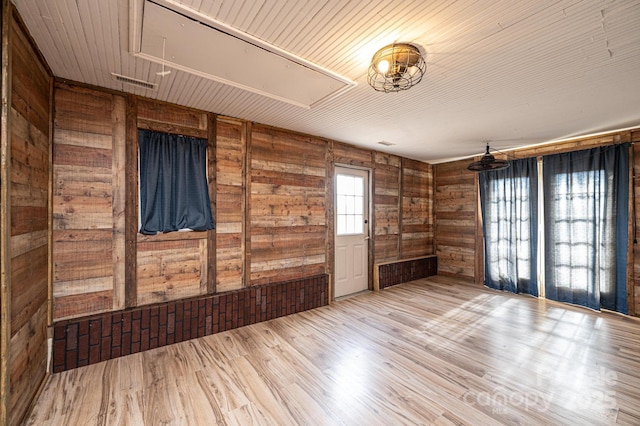 spare room featuring wooden ceiling, light hardwood / wood-style floors, and wood walls