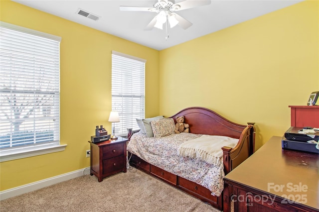 carpeted bedroom with ceiling fan and multiple windows