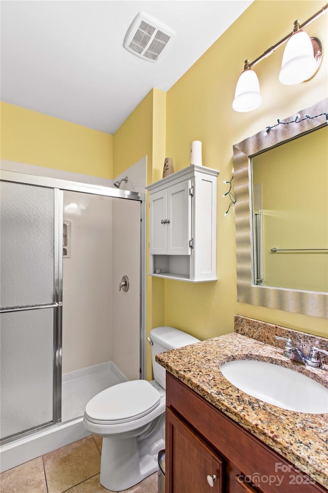 bathroom featuring vanity, tile patterned floors, toilet, and walk in shower