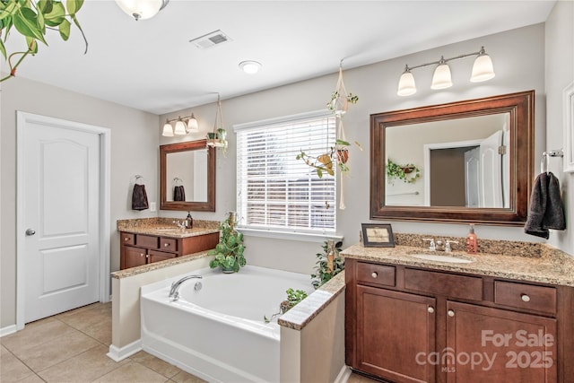 bathroom with a tub to relax in, tile patterned flooring, and vanity