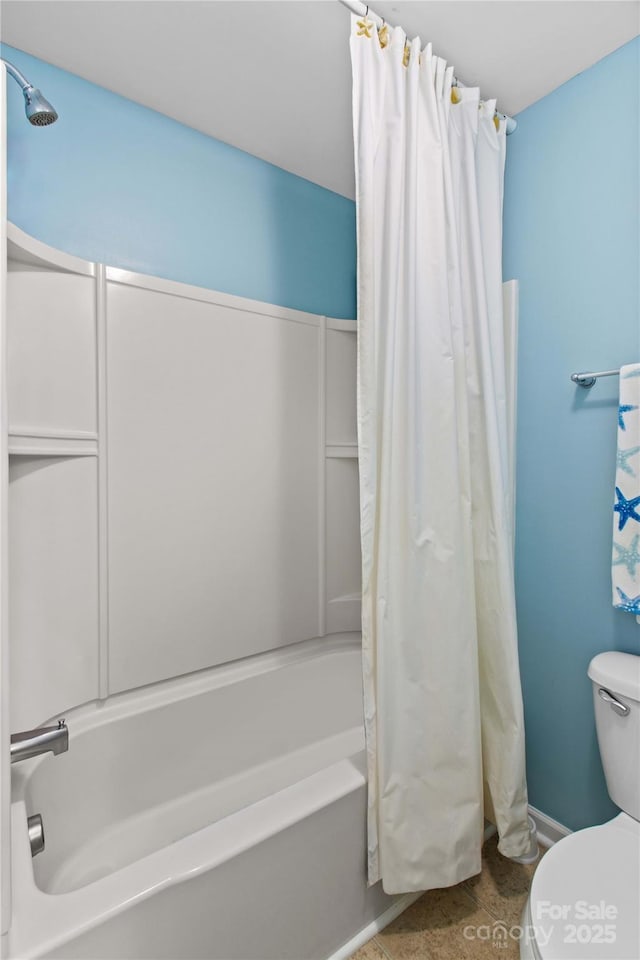 bathroom featuring tile patterned floors, toilet, and shower / bath combo with shower curtain