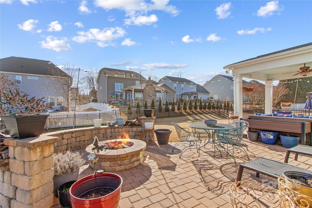 view of patio with ceiling fan and a fire pit