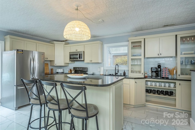 kitchen featuring sink, stainless steel appliances, a center island, ornamental molding, and decorative light fixtures