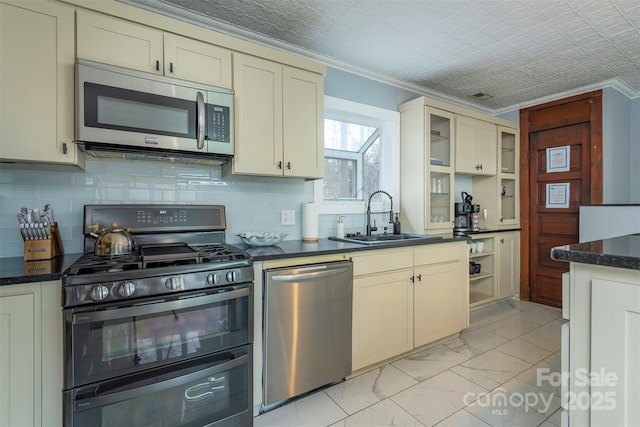 kitchen featuring sink, ornamental molding, stainless steel appliances, and cream cabinetry