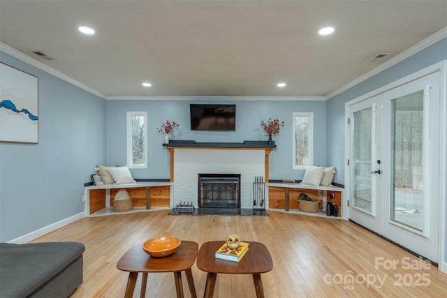 living room with crown molding, hardwood / wood-style flooring, and a fireplace