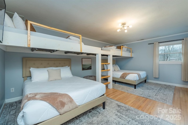 bedroom featuring hardwood / wood-style floors and ornamental molding