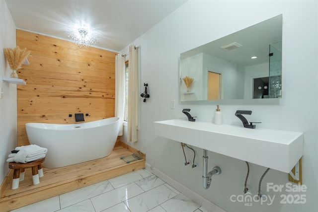 bathroom featuring wood walls and a tub