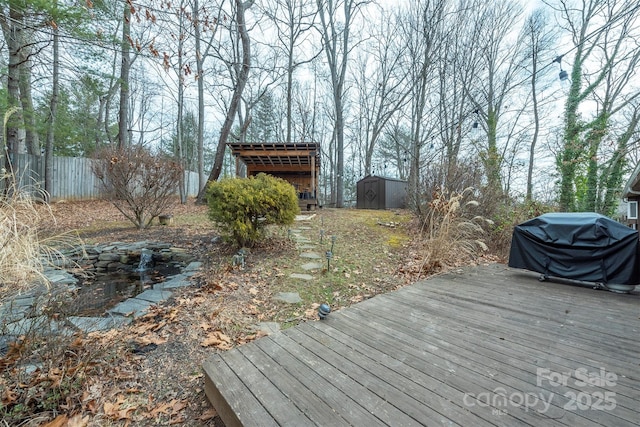 wooden terrace with a shed and a grill