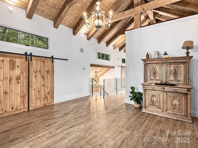 living room featuring dark hardwood / wood-style flooring, a barn door, a notable chandelier, and wood ceiling