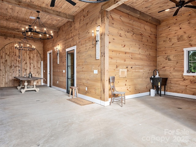 interior space featuring beam ceiling, ceiling fan with notable chandelier, wooden walls, and wooden ceiling