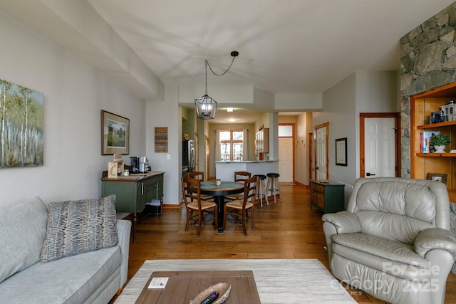 living room with dark wood-type flooring and a chandelier