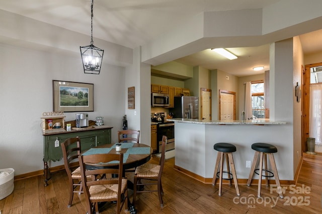 dining space with hardwood / wood-style flooring and a chandelier