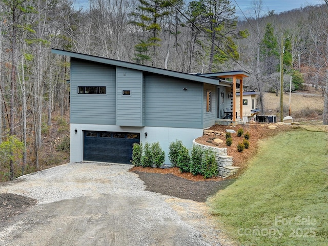 view of front facade featuring dirt driveway, a front lawn, a garage, and stucco siding