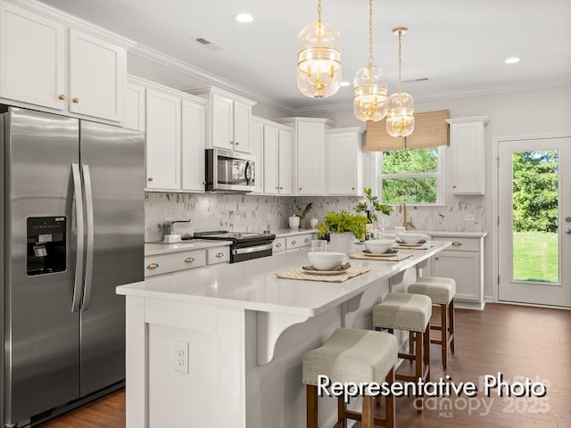 kitchen with white cabinetry, stainless steel appliances, and hanging light fixtures