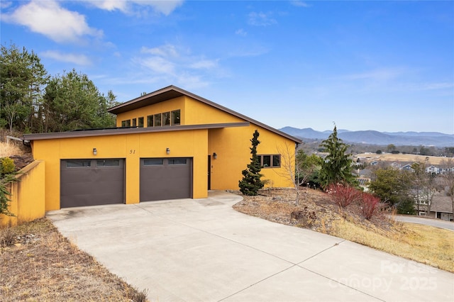 view of front facade featuring a garage and a mountain view