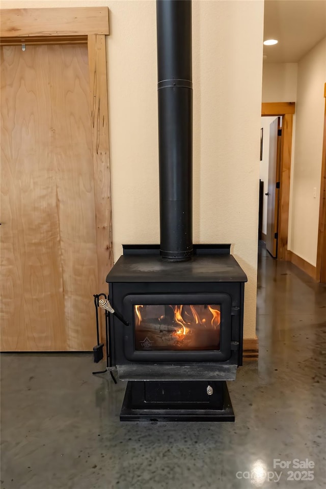 interior details featuring concrete floors and a wood stove