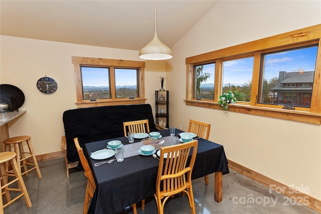 dining space with lofted ceiling and concrete flooring