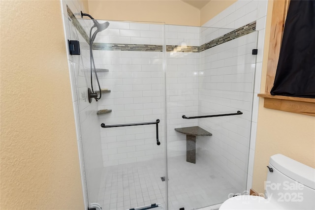 bathroom featuring walk in shower and toilet