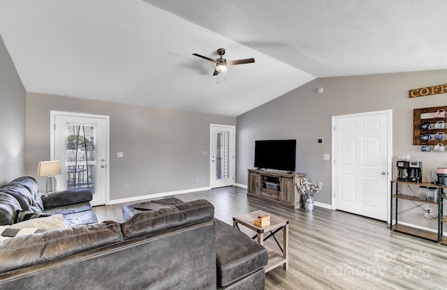 living room featuring lofted ceiling, light hardwood / wood-style flooring, and ceiling fan