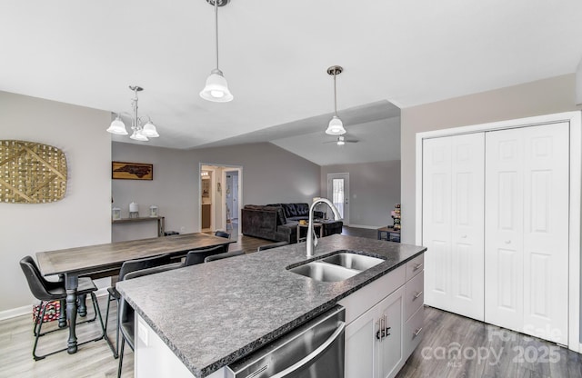 kitchen featuring sink, decorative light fixtures, stainless steel dishwasher, a kitchen island with sink, and white cabinets