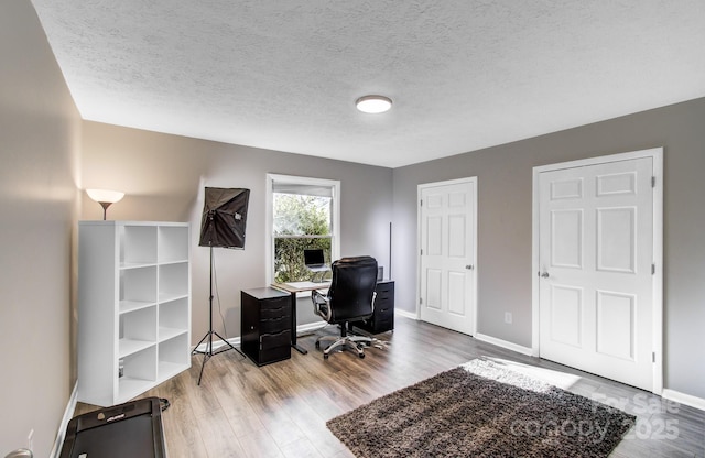 office area with hardwood / wood-style floors and a textured ceiling