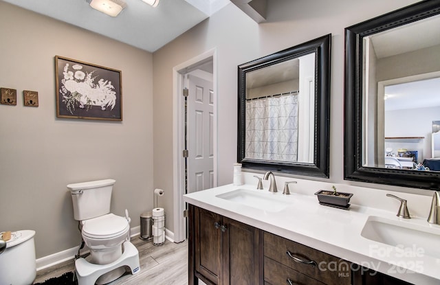 bathroom featuring vanity, hardwood / wood-style floors, and toilet