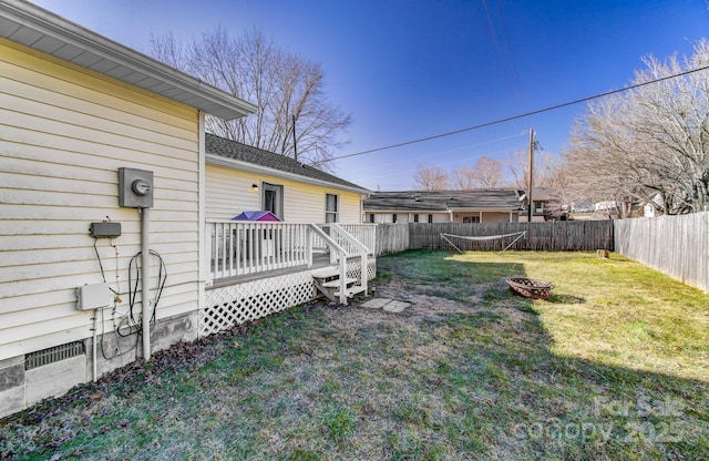 view of yard with a wooden deck and a fire pit