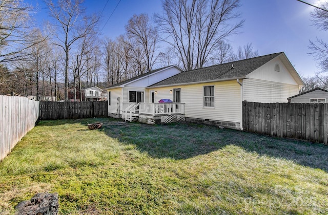 rear view of house featuring a yard and a deck