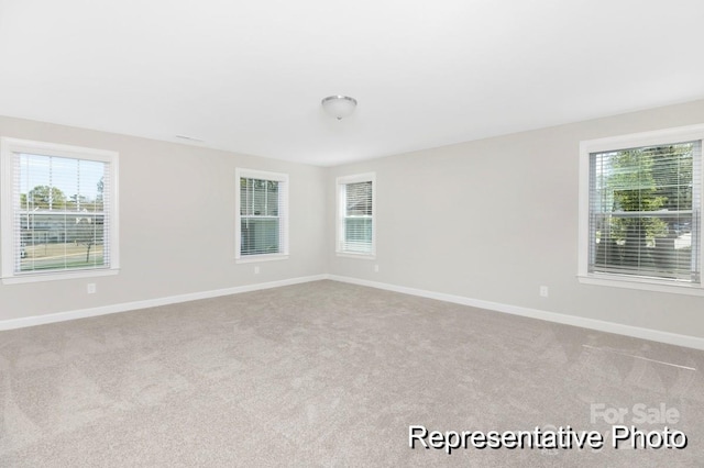 unfurnished room with plenty of natural light and light colored carpet