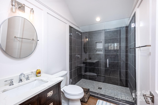 bathroom featuring tiled shower, vanity, and toilet