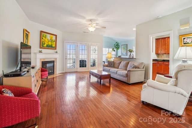 living room featuring wood-type flooring, ceiling fan, and french doors