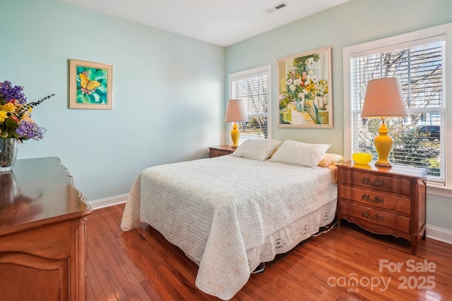 bedroom featuring multiple windows and hardwood / wood-style flooring