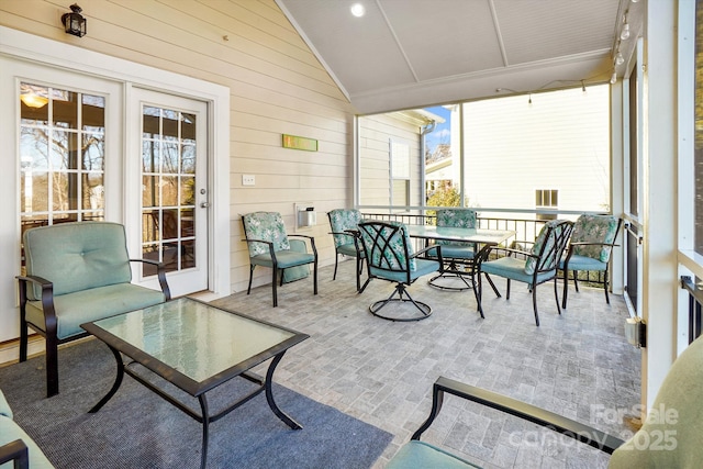 sunroom featuring vaulted ceiling