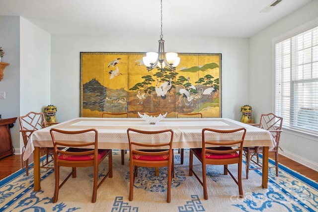 dining area with an inviting chandelier and hardwood / wood-style floors