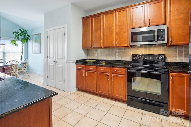 kitchen with black / electric stove, tasteful backsplash, and dark stone countertops