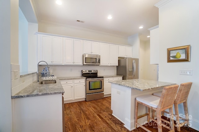 kitchen featuring white cabinetry, appliances with stainless steel finishes, sink, and light stone counters