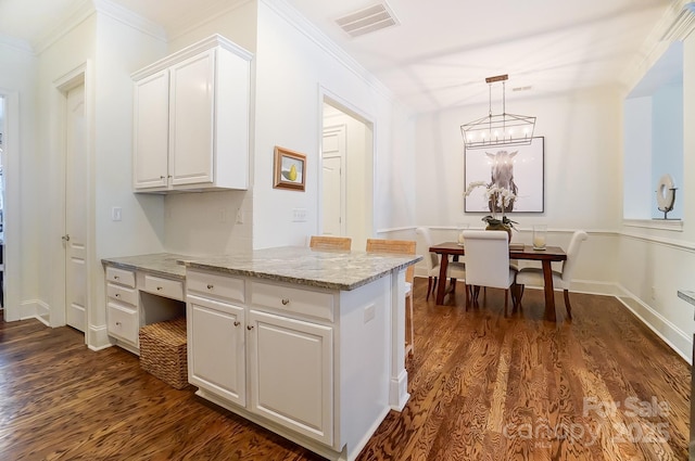 kitchen with dark wood-type flooring, crown molding, light stone counters, hanging light fixtures, and white cabinets